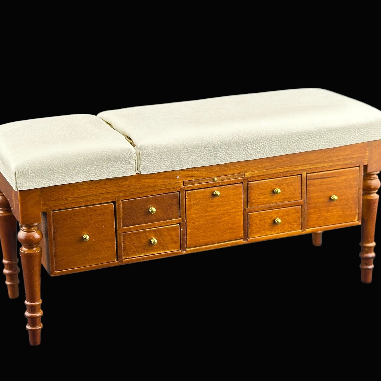 Wooden bench with cream cushions and drawers on a gray background