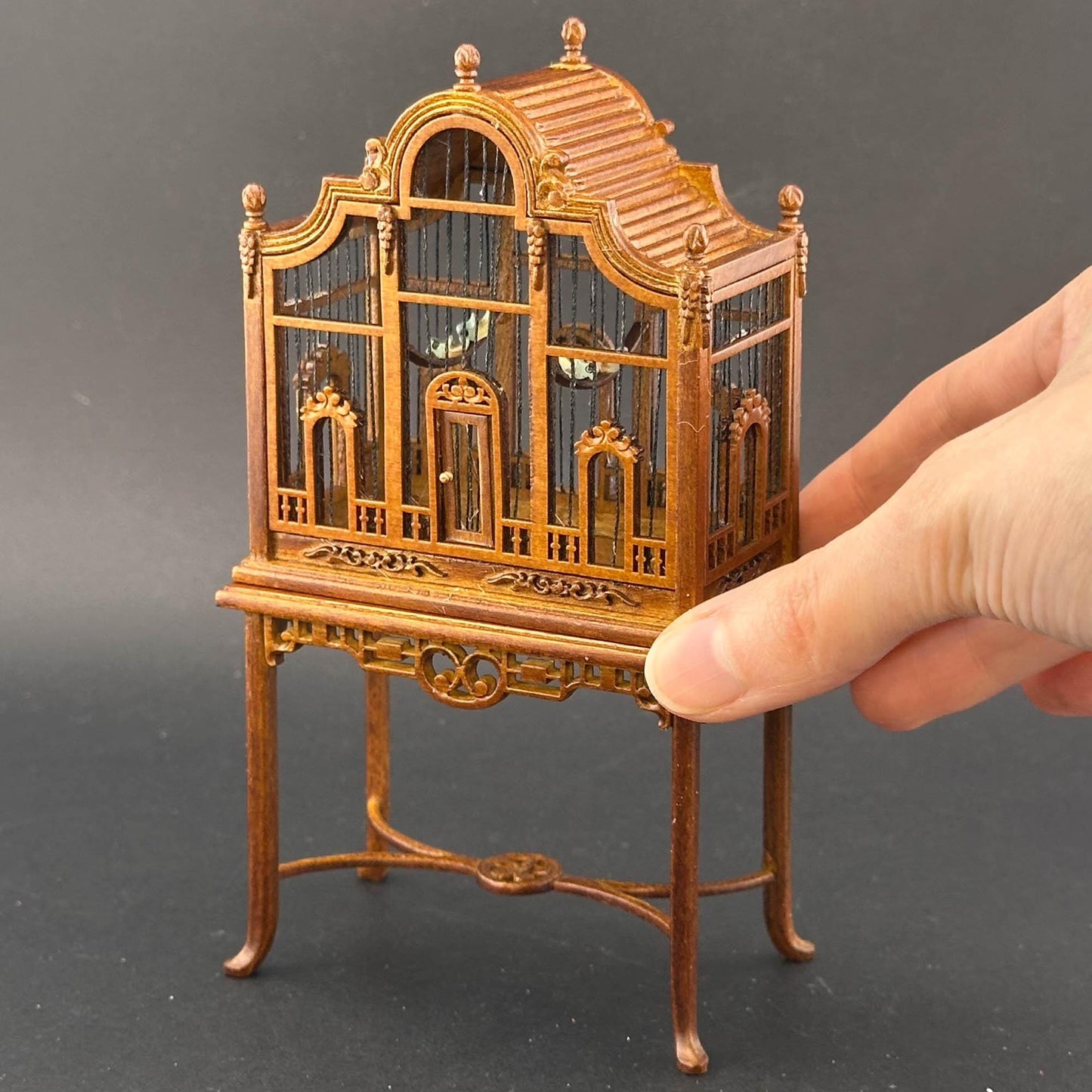 Une magnifique cage à oiseaux victorienne classique en bois avec une table pour une miniature de maison de poupée 1:12 en noyer