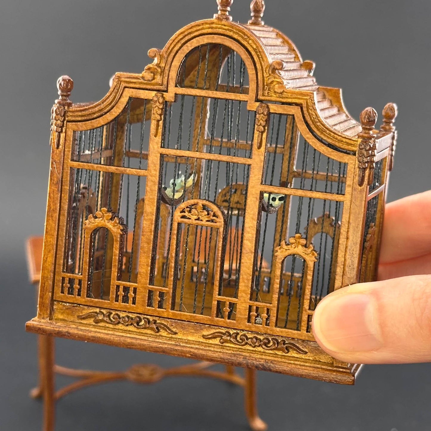 Une magnifique cage à oiseaux victorienne classique en bois avec une table pour une miniature de maison de poupée 1:12 en noyer