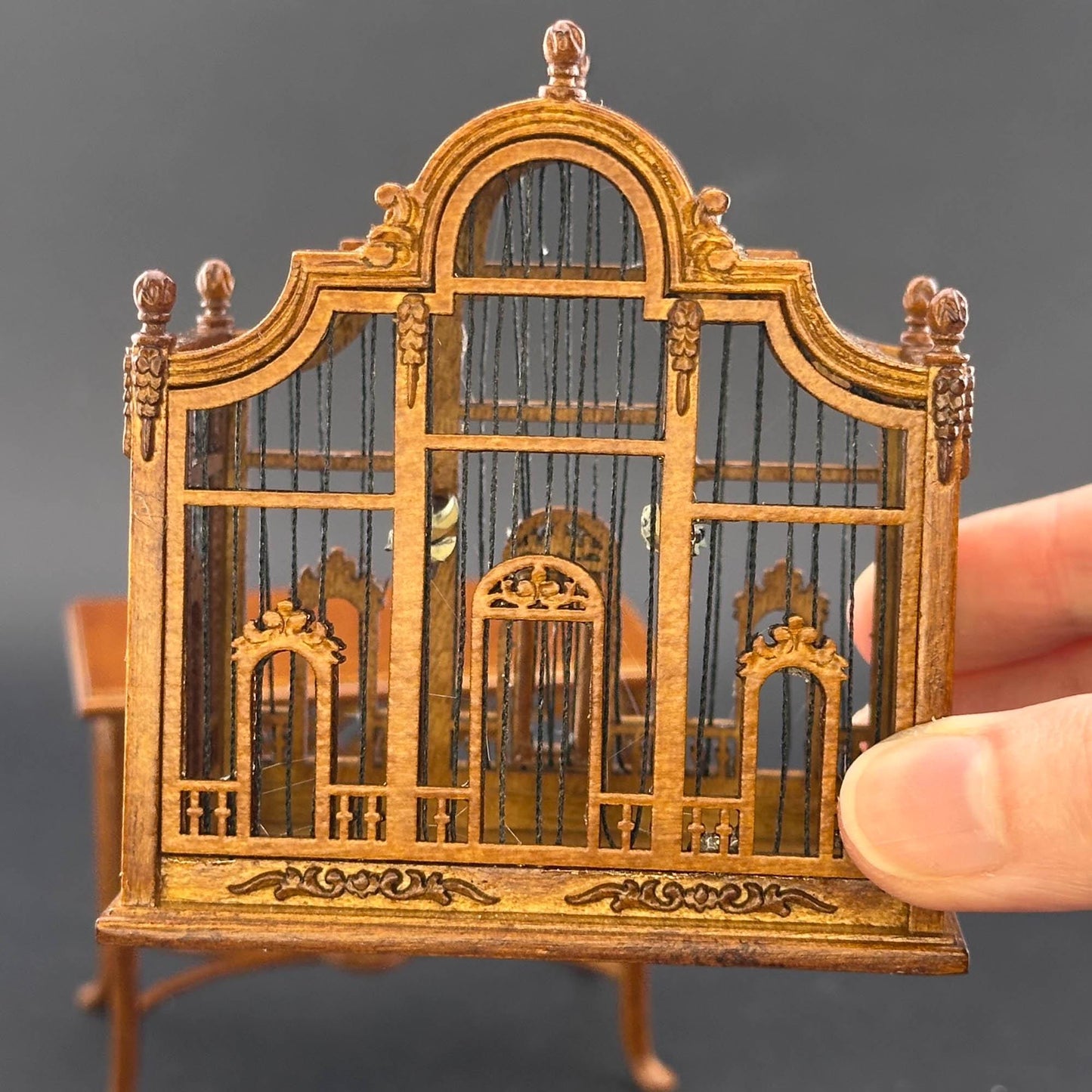 Une magnifique cage à oiseaux victorienne classique en bois avec une table pour une miniature de maison de poupée 1:12 en noyer