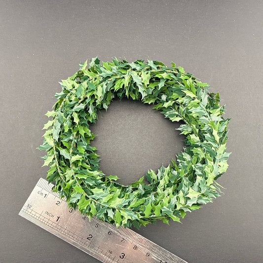 Green leafy wreath with a ruler for scale on a gray background