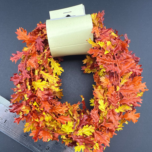 Autumn leaf wreath with a ruler for scale on a dark background
